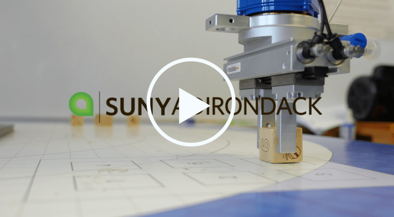 A robotic arm picks up blocks in a Mechatronics lab at SUNY Adirondack