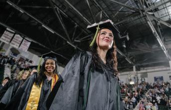 Graduates smile as they enter Cool Insuring Arena at the 2024 commencement ceremony
